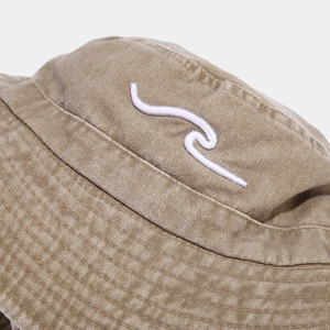 Detailed view of wave embroidery on washed cotton sun hat with vintage fabric texture