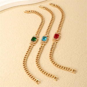 Golden Cuban link bracelets featuring emerald, aquamarine, and ruby cubic zirconia stones
