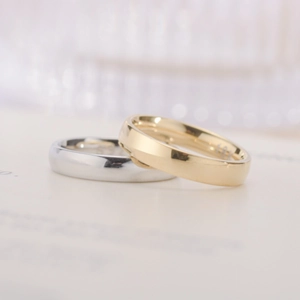 Macro shot of minimalist gold 18K and silver S925 rings with polished mirror finish