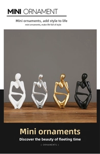 Close-up of four abstract thinker resin statues in white, silver, gold, and black colors
