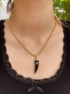Close-up of 18k gold bead chain with black horn devil's eye pendant worn on a model