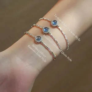 Detail of silver bamboo and nugget bracelets with natural aquamarine stones on woman wrist