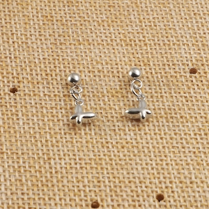 Gros plan sur les boucles d'oreilles clous en acier argenté avec pendentif papillon