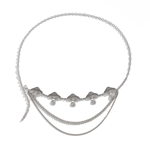 Detail of silver multilayer waist chain with intricate mushroom pendants on white background