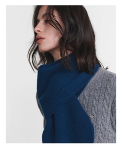Detailed texture of a soft dark blue Australian wool scarf on a gray knit sweater