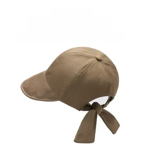Detail of a brown baseball cap featuring a stylish bow tie adjustment on the back