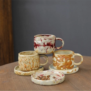 Macro detail of three handmade ceramic coffee mugs and saucers with artistic glaze spots