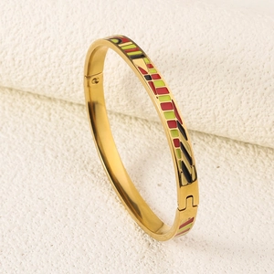 Detailed macro view of 18K gold plated bangle featuring colorful enamel pattern inlays