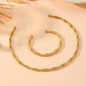 Close-up of golden bamboo joint necklace and bracelet with polished metallic finish
