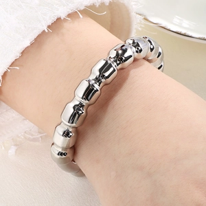 Close-up of a silver segmental chunky bangle with polished bamboo-like texture on wrist