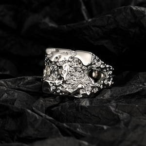 Irregular silver molten lava texture ring with geometric wide band in a macro view
