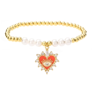 Golden bead and pearl bracelet featuring a red heart devil's eye charm on white background
