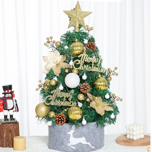 Mini tabletop Christmas tree with gold ornaments and reindeer base on white background