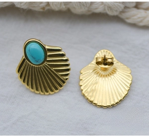 Detailed view of bohemian 18K gold fan-shaped stud earrings with turquoise stones