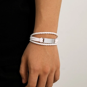 Detail showing white multi-layer woven leather bracelet with silver metal plate on wrist