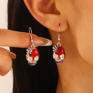 Halloween vintage skull earrings with red drip enamel design worn on model's ear