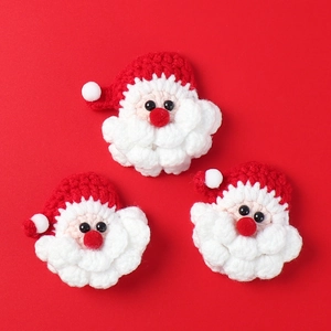 Détail de trois patchs de Père Noël faits main au crochet pour loisirs créatifs