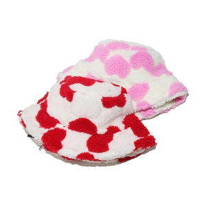 Detail of plush bucket hats with red and pink heart patterns in soft faux fur material