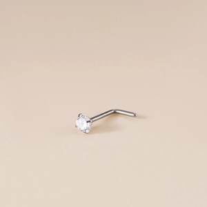 Titanium L-shaped nose stud with sparkling round cubic zirconia stone on beige background