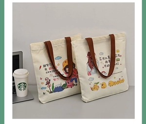 Detail view of canvas tote bags featuring cute cartoon girls and motivational text