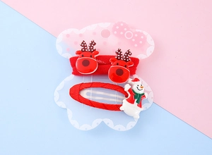 Close-up of Christmas hair clips set with red reindeer antlers and snowman design