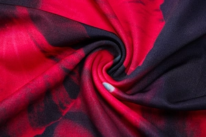 Gros plan détaillé du tissu brillant à imprimé floral rouge foncé et noir texturé