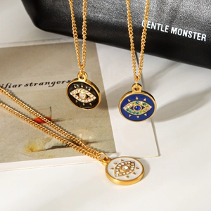 Detailed macro of Evil Eye pendant necklaces in black, blue, and white enamel finish