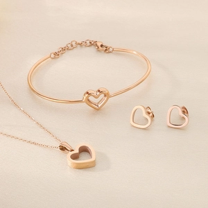 Vue détaillée de l'ensemble de bijoux cœur évidé en or rose avec collier et gourmette