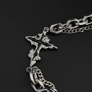 Detail of cross pendant with black enamel and white zircon on a dual steel chain