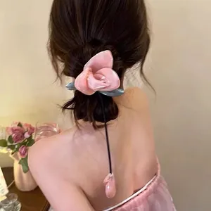 Pink rose hair claw clip with long tassels worn on bun hairstyle, floral aesthetic