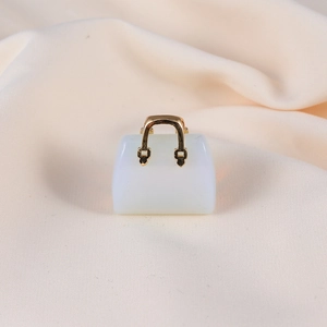 Detailed macro view of a white crystal handbag pendant with elegant gold metal handle