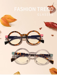 Close-up of retro round tortoiseshell and clear grey glasses frames with autumn maple leaves