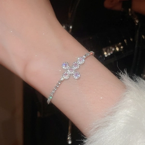 Detailed macro shot of a sparkling silver cross bracelet with pink and white zirconia stones