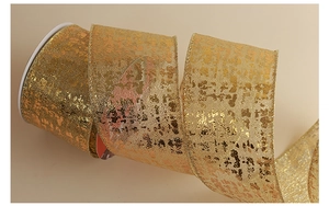Détail macro d'un ruban doré moucheté de qualité pour emballage cadeau de Noël