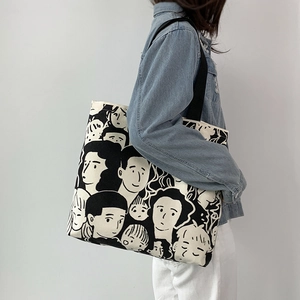 Vista laterale della borsa tote in tela grande con stampa in bianco e nero su modella
