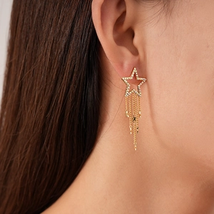 Elegant gold star tassel earrings with colorful zircons worn by a female model