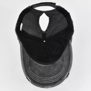 Macro view of washed dark grey cotton baseball cap showing ponytail hole and internal seams