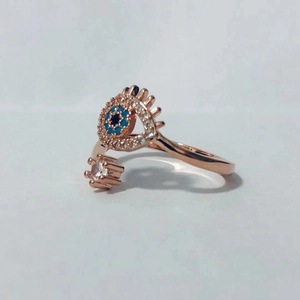 Detalle del anillo de ojo azul en oro rosa con detalles de cristales brillantes