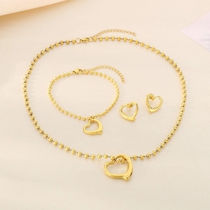Three-piece golden hollow heart jewelry set with beaded necklace, bracelet and earrings