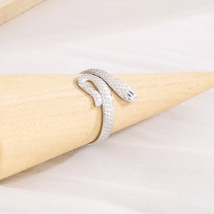 Detailed view of silver snake ring with textured scales on a wooden display stand