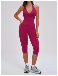 Detail view of high elasticity fuchsia cross-neck sports bra and cropped yoga leggings