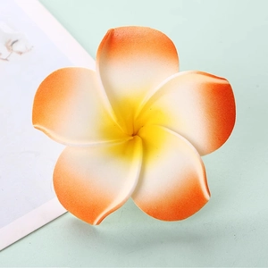 Macro shot of realistic Plumeria EVA foam flower with yellow orange gradient petals