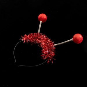 Detail of red glitter balls and metallic springs on a festive alien antenna headband