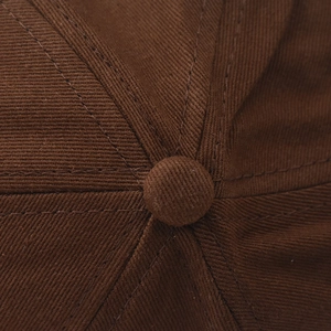 Makroaufnahme von dunkelbraunem Twill-Baumwoll-Baseballcap-Knopf und Nahtdetails
