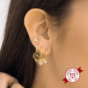 Detail of 925 sterling silver heart-shaped diamond stud earring on a model