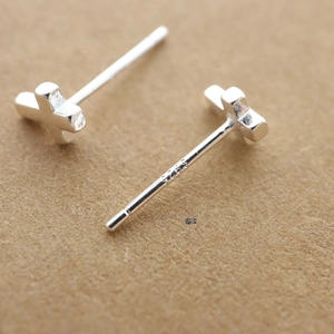 Macro view of minimalist 925 sterling silver cross stud earrings showing the S925 hallmark