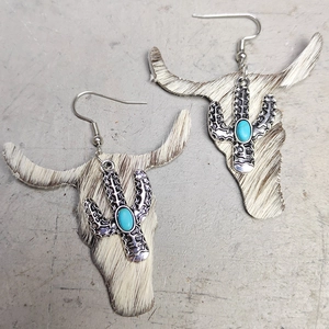 Detail of Western bull skull earrings featuring real cowhide and turquoise cactus accent