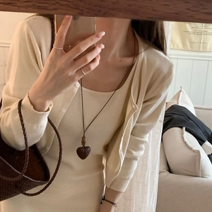 Vintage wooden heart necklace with bamboo chain, styled with beige knit sweater