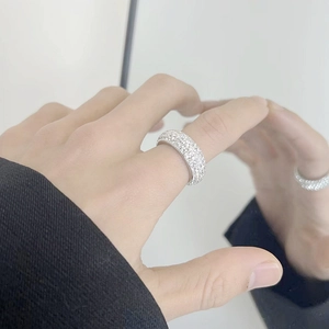 Close-up of a wide titanium steel ring with five rows of sparkling pave-set diamonds