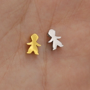 Macro view of gold and silver stainless steel girl shaped charms on a hand palm